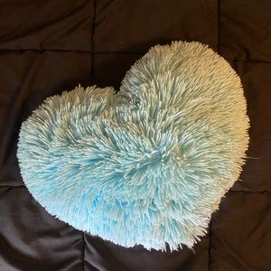 A cute blue heart pillow that 16 inch in width and 12 inch in length.
